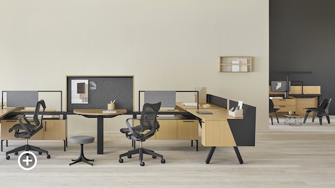 Uma estação de trabalho Canvas Vista com uma área de colaboração e cadeiras de escritório Cosm pretas em primeiro plano, e uma área de colaboração Canvas Vista ao fundo. Selecione para ir até a página de Estações de trabalho colaborativas no Canvas Lookbook.
