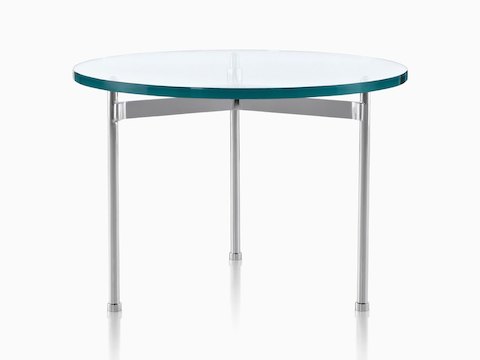 Una mesa de cristal Claw Table con una superficie redonda y tres patas de metal.