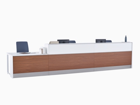 Mostrador de enfermería Commend con tapas en Corian blanco, sillas Verus de color azul, laminado que imita la madera de nogal y zócalos de acero inoxidable. Mostrador de enfermería Commend con tapas en Corian blanco, sillas Verus de color azul, laminado que imita la madera de nogal y zócalos de acero inoxidable.