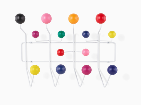 Un estante de almacenamiento Eames Hang-It-All, con un marco de alambre blanco y perillas de madera multicolores.