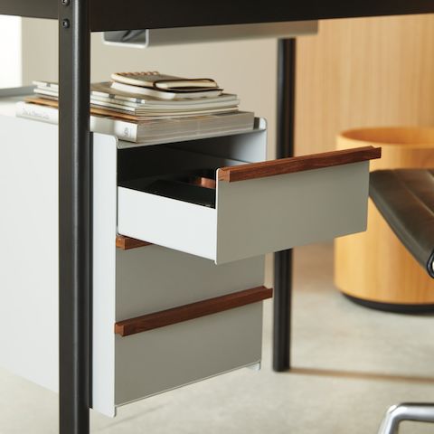 Captura en detalle del escritorio Mode en negro con cajones en sandstone y tiradores de madera, en un esquema de home office. Captura en detalle del escritorio Mode en negro con cajones en sandstone y tiradores de madera, en un esquema de home office.