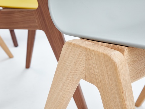 Una vista en primer plano de la base de roble de una silla de madera Polly Wood de NaughtOne gris.