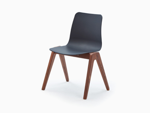 Una Silla de Madera Polly NaughtOne negra con base de nogal, vista desde un ángulo. Una Silla de Madera Polly NaughtOne negra con base de nogal, vista desde un ángulo.