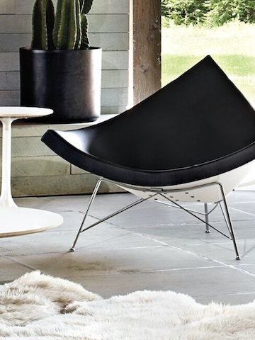 Um couro preto Nelson Coconut Lounge Chair em um pátio ao ar livre. Um couro preto Nelson Coconut Lounge Chair em um pátio ao ar livre.