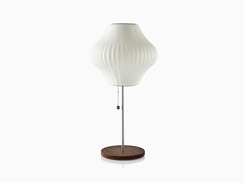 Una lámpara de mesa Nelson Pear Lotus blanca con una base de acero cubierta de nogal.