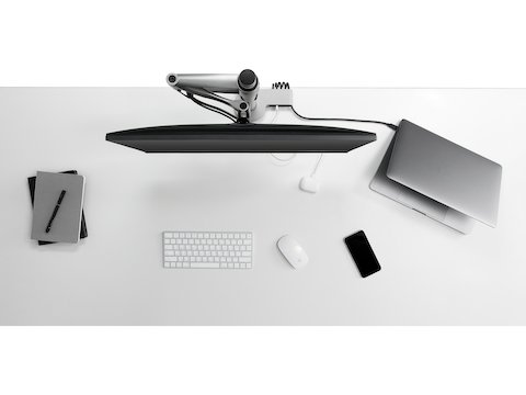 Vista aérea de un brazo articulado para monitor de la marca Wishbone integrado con un módulo de conectividad Ondo en un escritorio y conectado a un computador portátil y un teléfono. Vista aérea de un brazo articulado para monitor de la marca Wishbone integrado con un módulo de conectividad Ondo en un escritorio y conectado a un computador portátil y un teléfono.