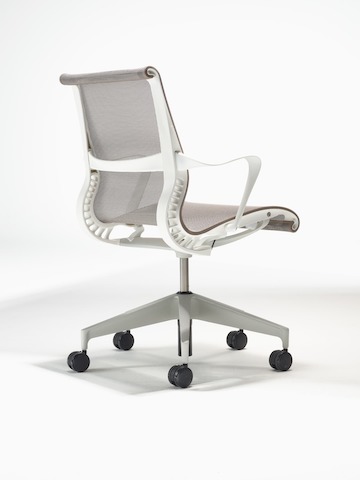 Vista de ángulo bajo trasero de una silla Setu con brazos fijos, marco en studio white, base de aleación en plateado y suspensión en cocoa brown.