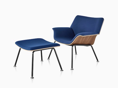 Tumbona Swoop de madera laminada y descansapiés con tapicería en azul regio vistos desde un ángulo de 45 grados.