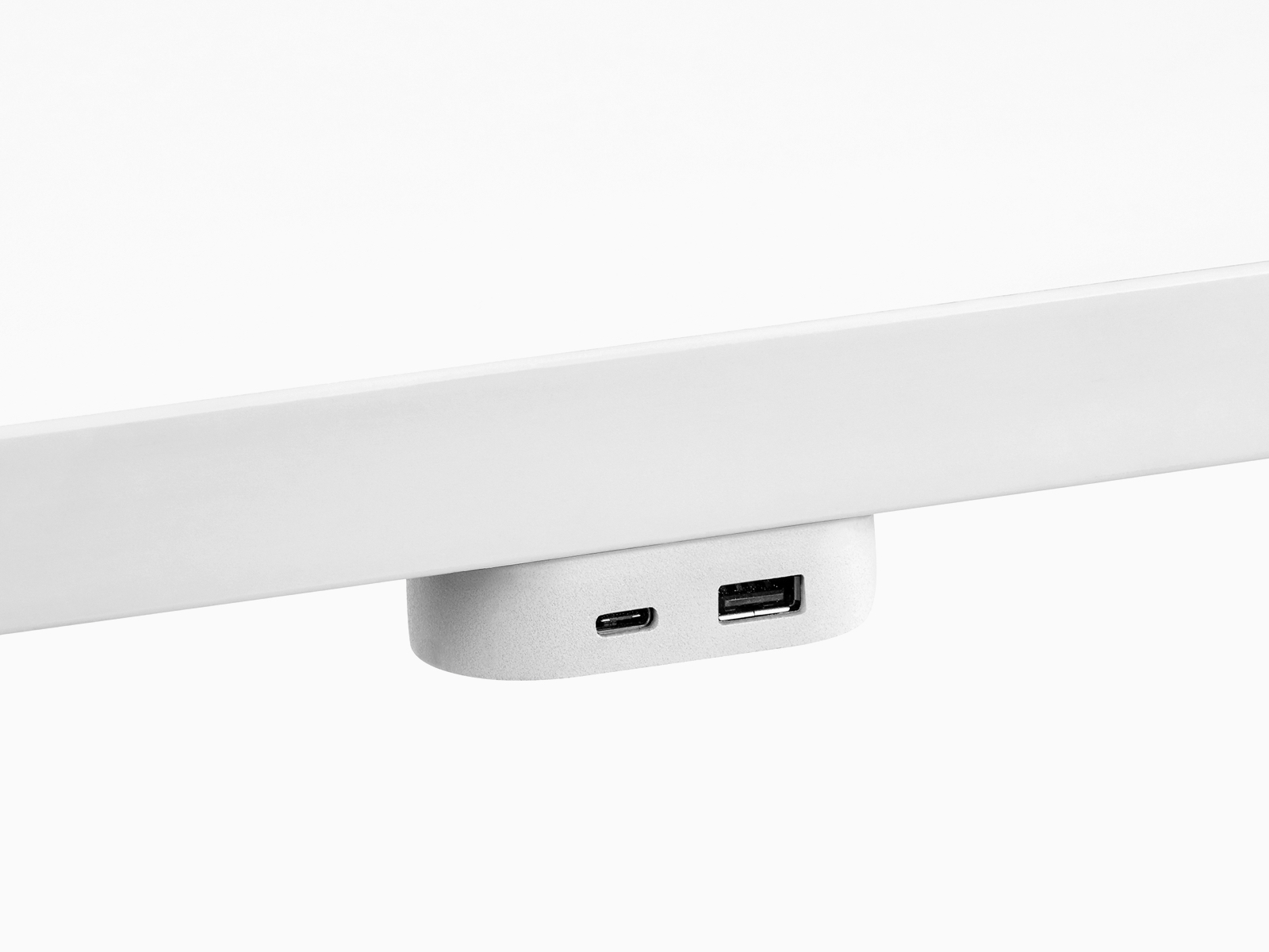 Un módulo de alimentación USB Ubi conectado a la parte inferior de una superficie de trabajo y que contiene dos puertos USB de diferentes tamaños.