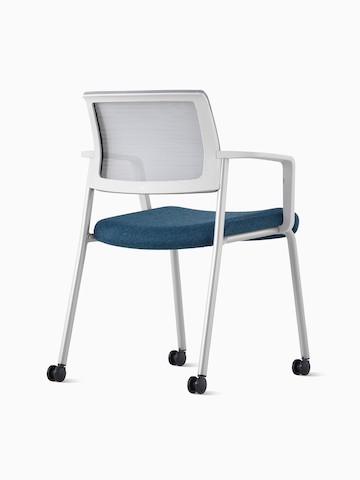 Vista lateral posterior de una silla de visita Verus tapizada en azul con respaldo de suspensión y brazos en blanco.