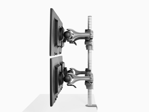 Vista de perfil de cuatro monitores conectados a un solo poste de brazo de monitor Wishbone Plus de alta resistencia.