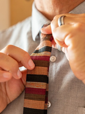 Se ajusta una corbata con estampado colorido.