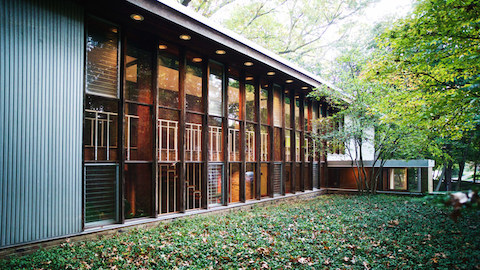 El exterior de una casa moderna con una pared de ventanas. Seleccione para ir a un artículo sobre una casa diseñada por George Nelson.